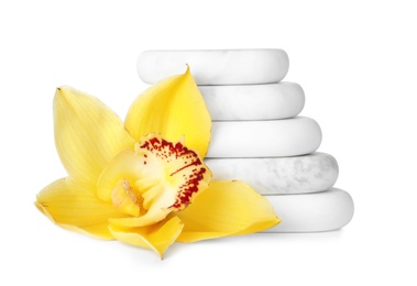 Stacked spa stones and beautiful orchid on white background