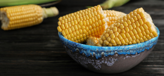 Image of Raw corn cobs in bowl on table, closeup with space for text. Banner design
