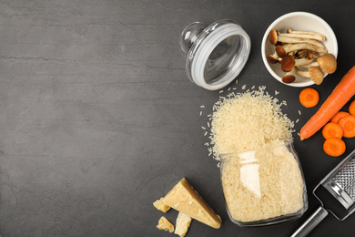 Flat lay composition with different ingredients on black table, space for text. Risotto recipe