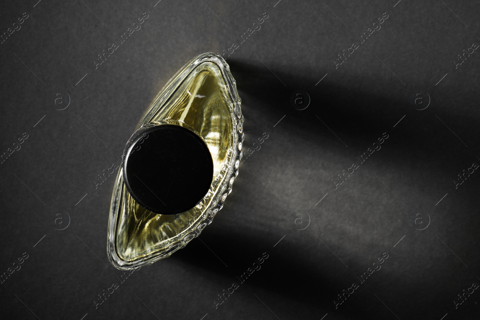 Photo of Luxury men`s perfume in bottle on black background, top view. Space for text