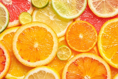 Slices of fresh citrus fruits as background, top view