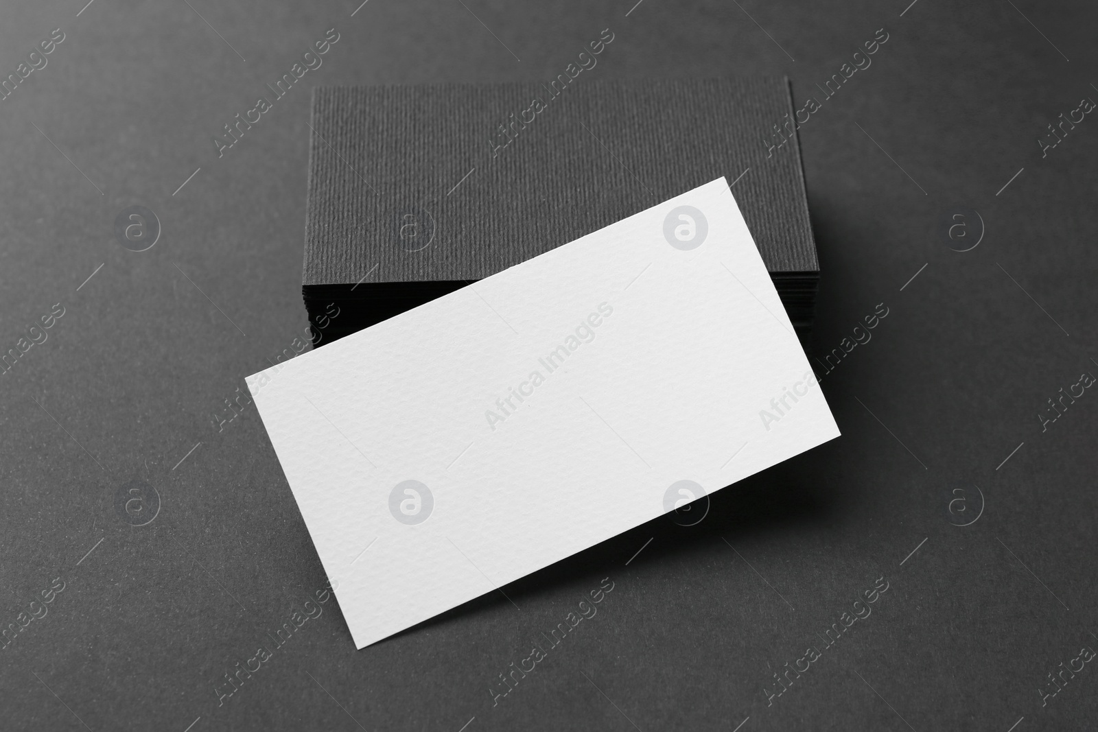 Photo of Blank business cards on black background, closeup. Mockup for design