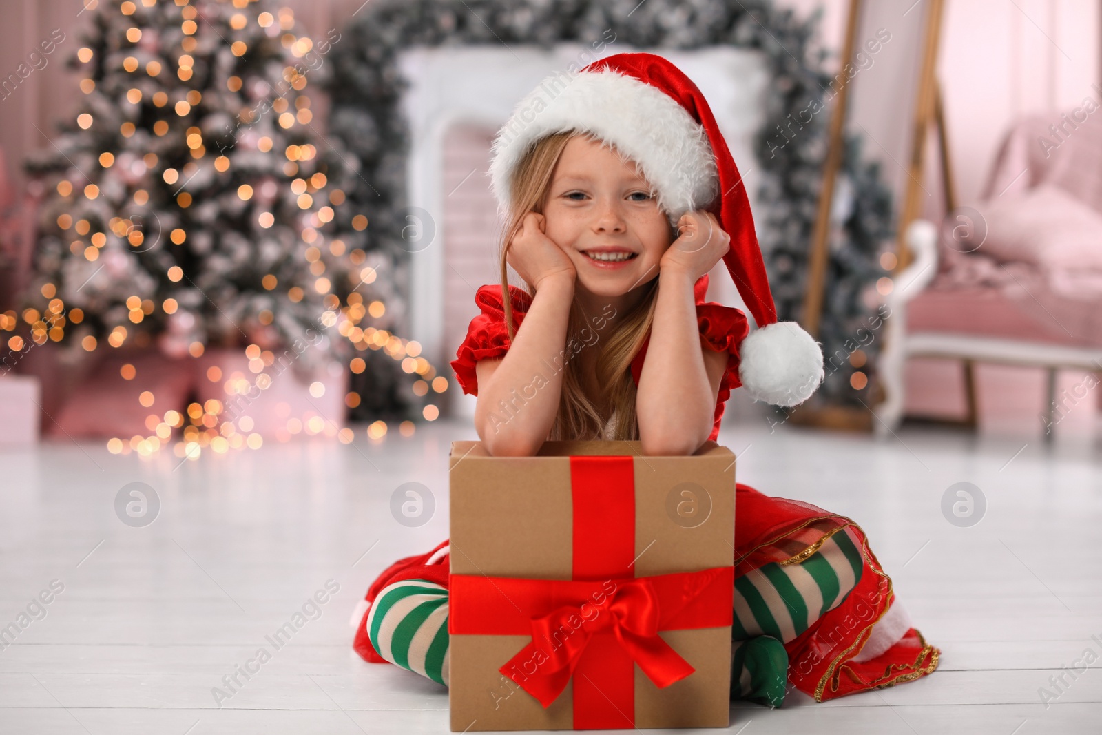 Photo of Cute little child with Christmas gift at home