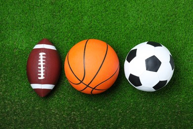 Photo of Set of different sport balls on green grass, flat lay