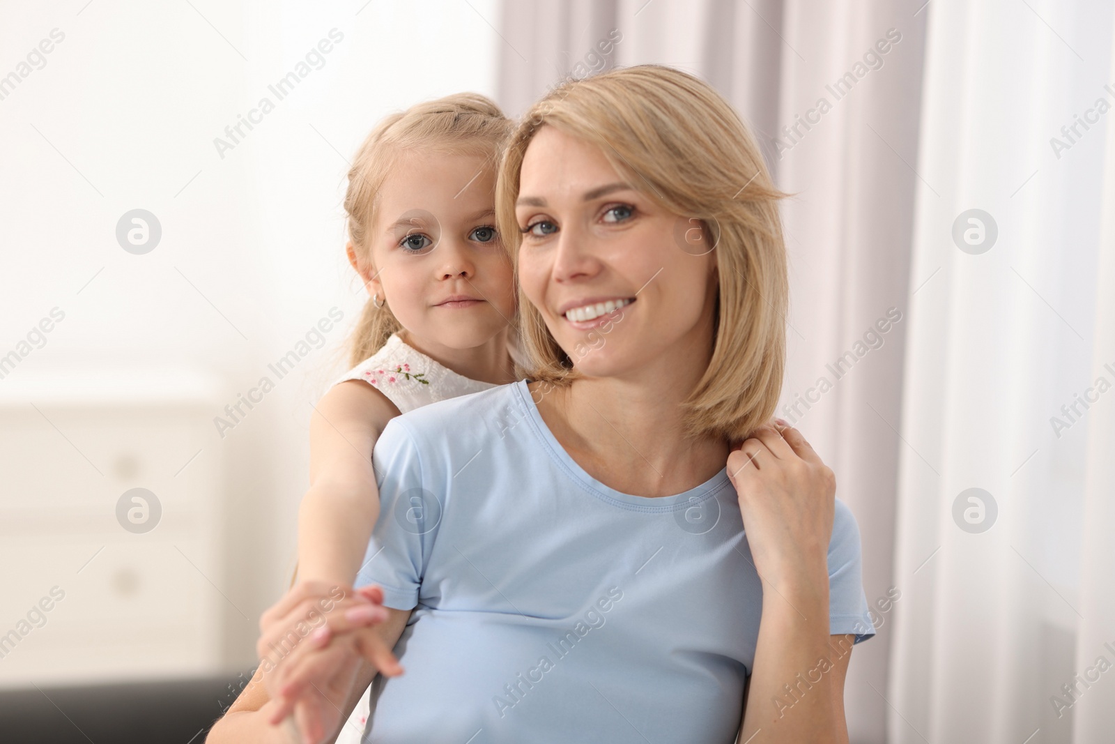 Photo of Family portrait of happy mother and daughter at home