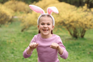 Easter celebration. Cute little girl with bunny ears outdoors