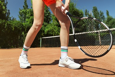 Photo of Woman playing tennis on court during sunny day, closeup