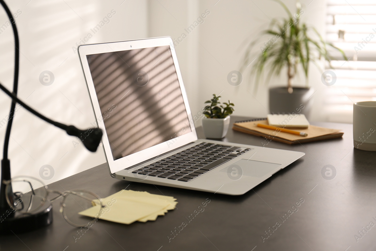 Photo of Modern laptop on office table. Stylish workplace