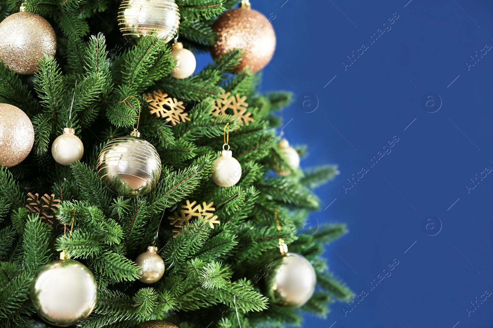 Photo of Beautiful Christmas tree with decor against blue background. Space for text