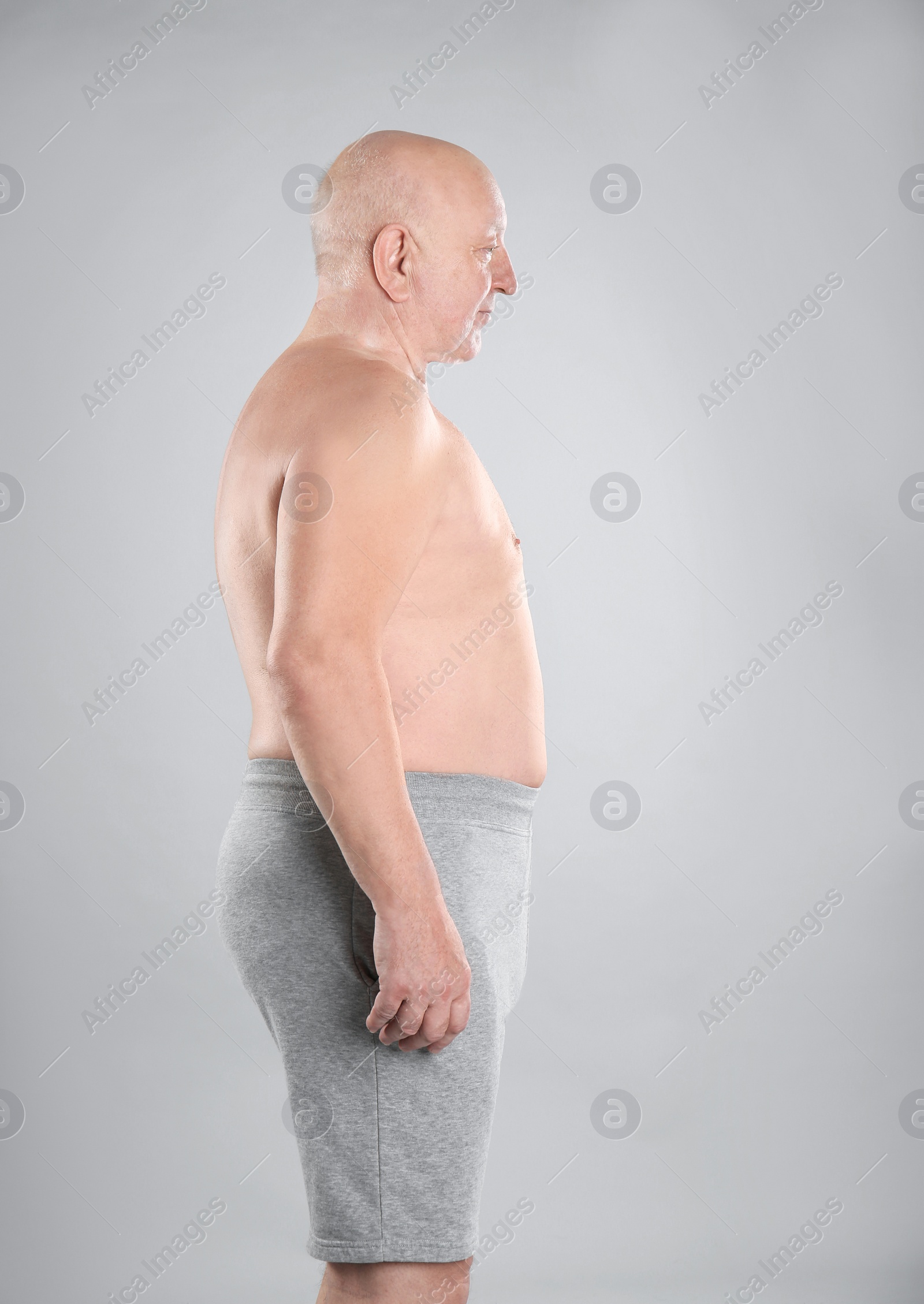 Photo of Fat senior man on grey background. Weight loss