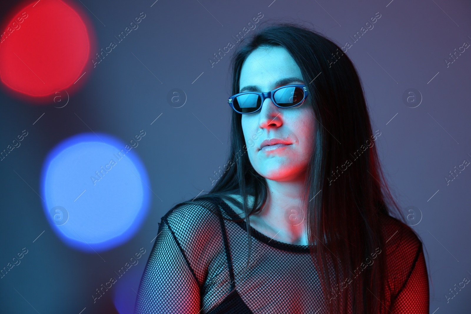 Photo of Portrait of beautiful young woman with sunglasses on color background