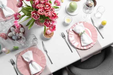 Photo of Festive table setting with beautiful flowers, top view. Easter celebration