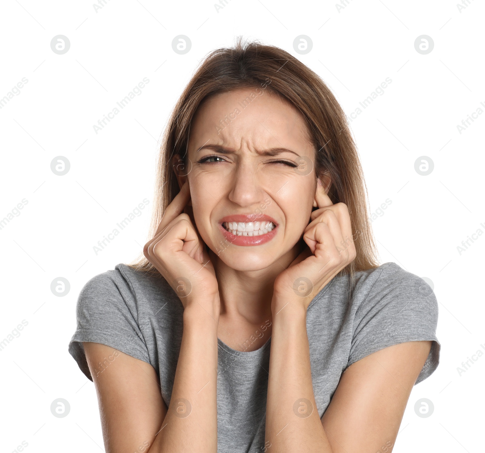 Photo of Emotional young woman covering her ears with fingers on white background