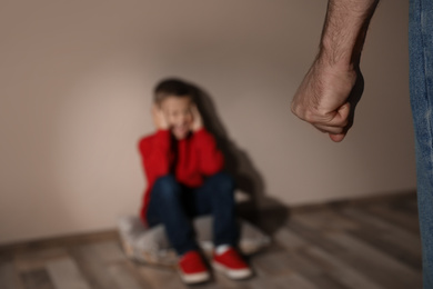 Man threatening his son indoors, closeup. Domestic violence concept