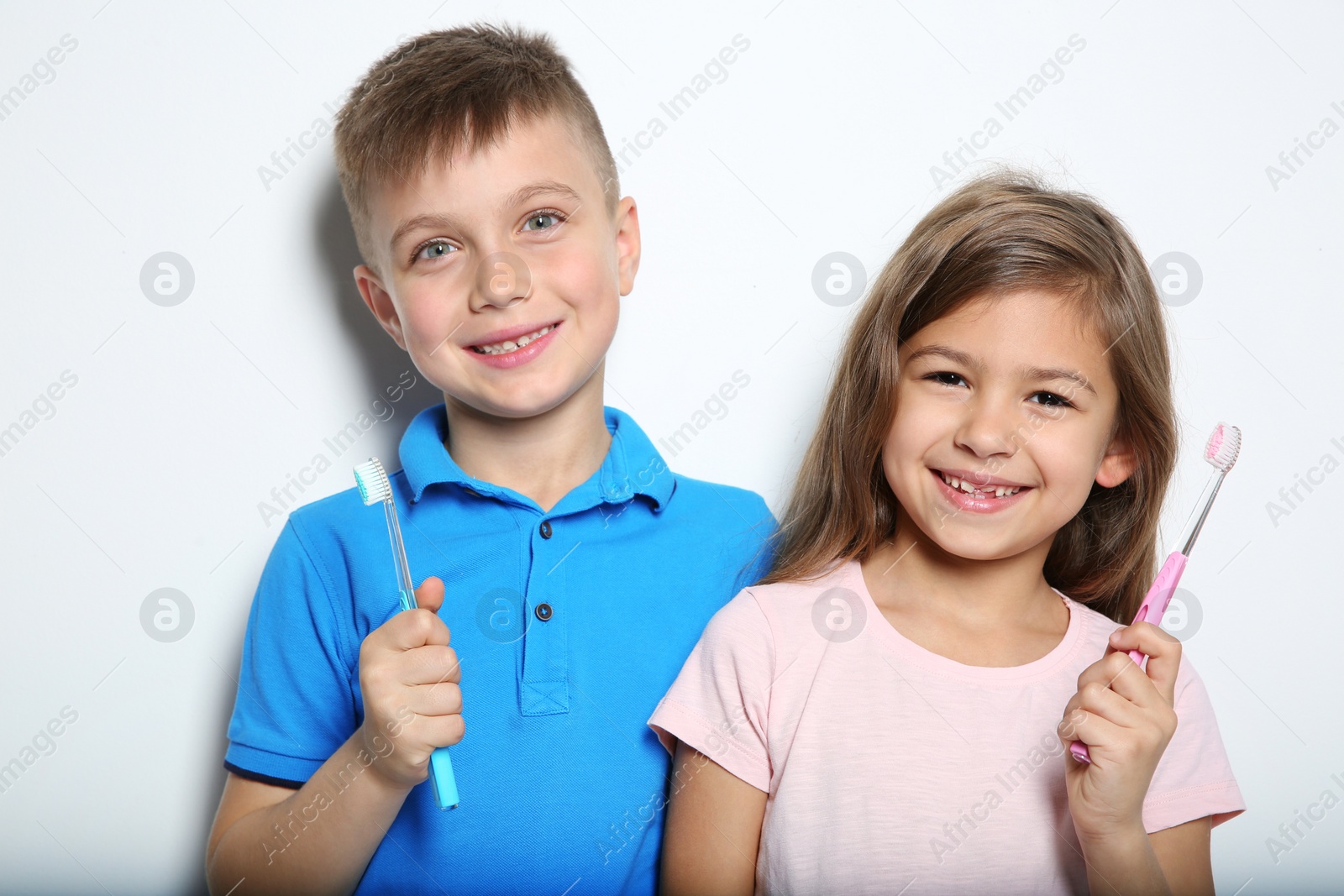 Photo of Portrait of cute children with toothbrushes on white background