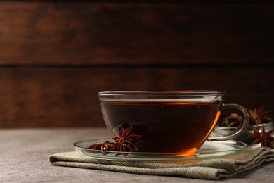 Photo of Aromatic tea with anise stars on light grey table. Space for text