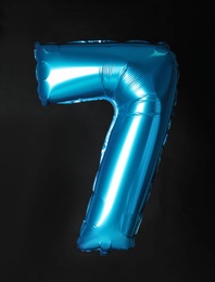 Photo of Blue number seven balloon on black background