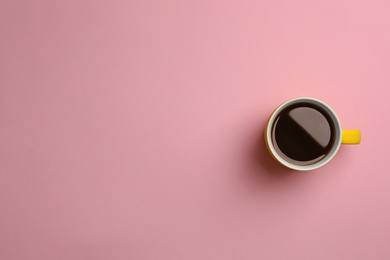 Ceramic cup with hot aromatic coffee on color background, top view