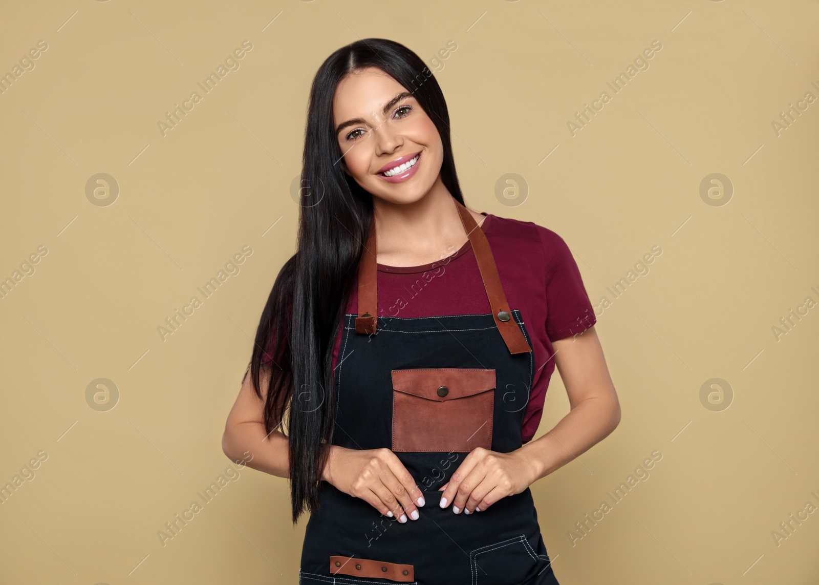 Photo of Portrait of happy hairdresser on beige background