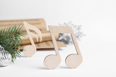 Photo of Wooden music note and fir tree branch with Christmas ball on white background