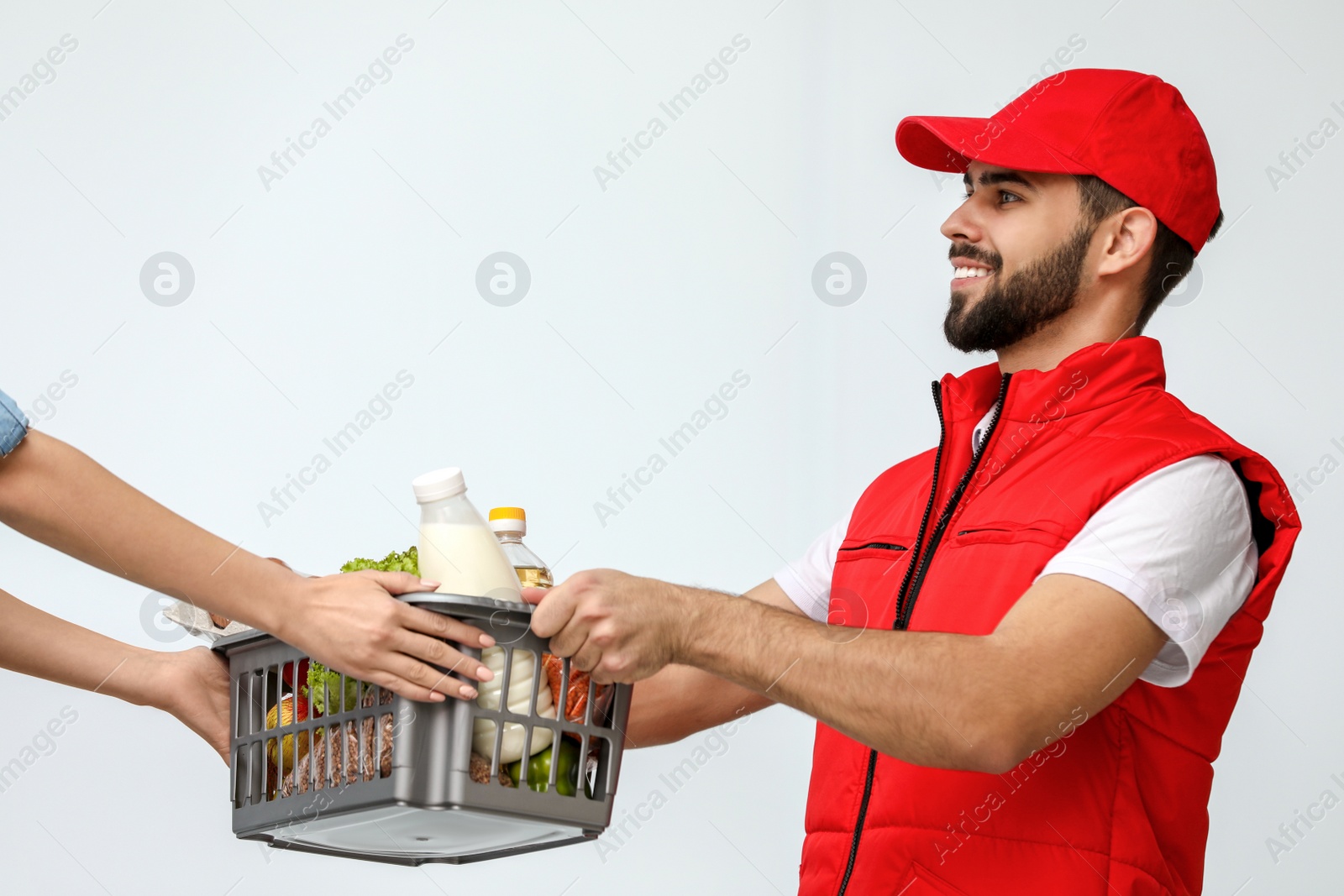 Photo of Young man delivering food to customer indoors