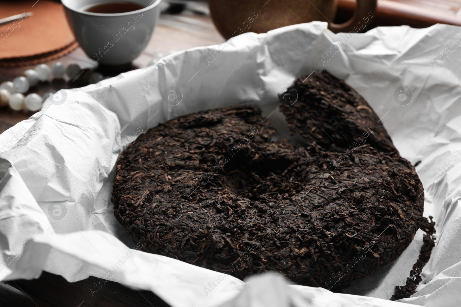 Photo of Broken disc shaped pu-erh tea on parchment paper