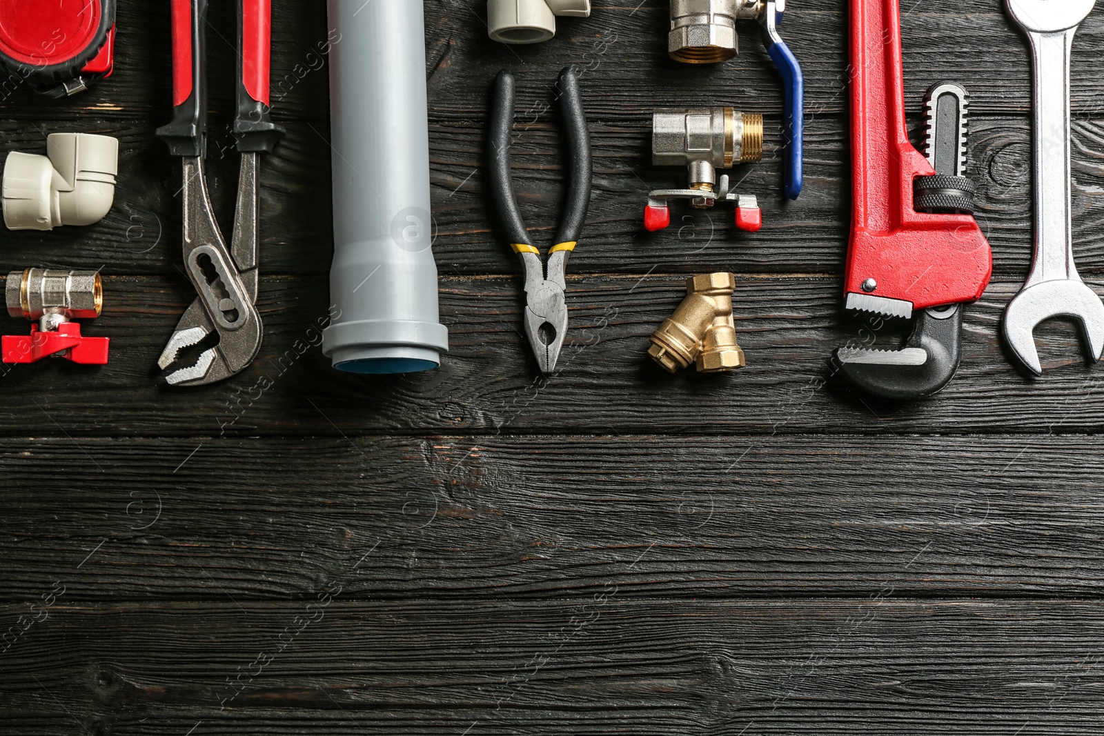 Photo of Flat lay composition with plumber's tools and space for text on wooden background