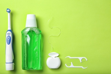 Photo of Flat lay composition with electric toothbrush and oral hygiene products on color background