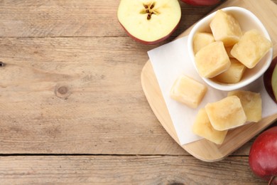 Photo of Frozen apple puree cubes and ingredient on wooden table, flat lay. Space for text