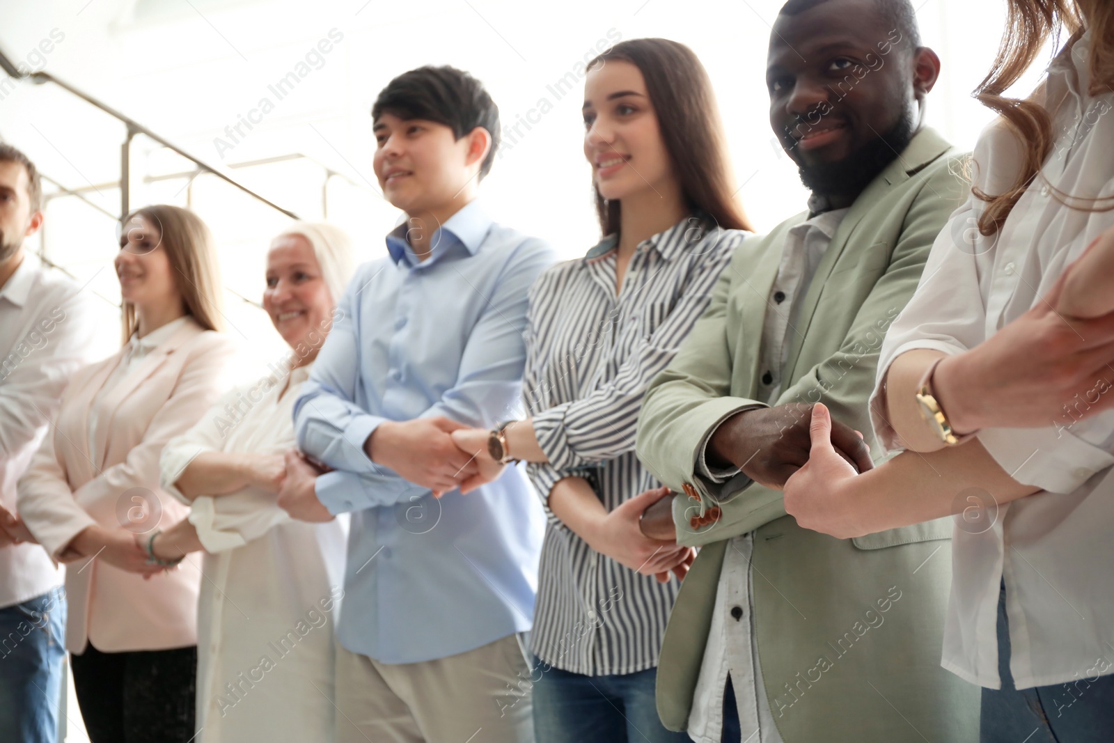 Photo of People holding hands indoors. Unity concept