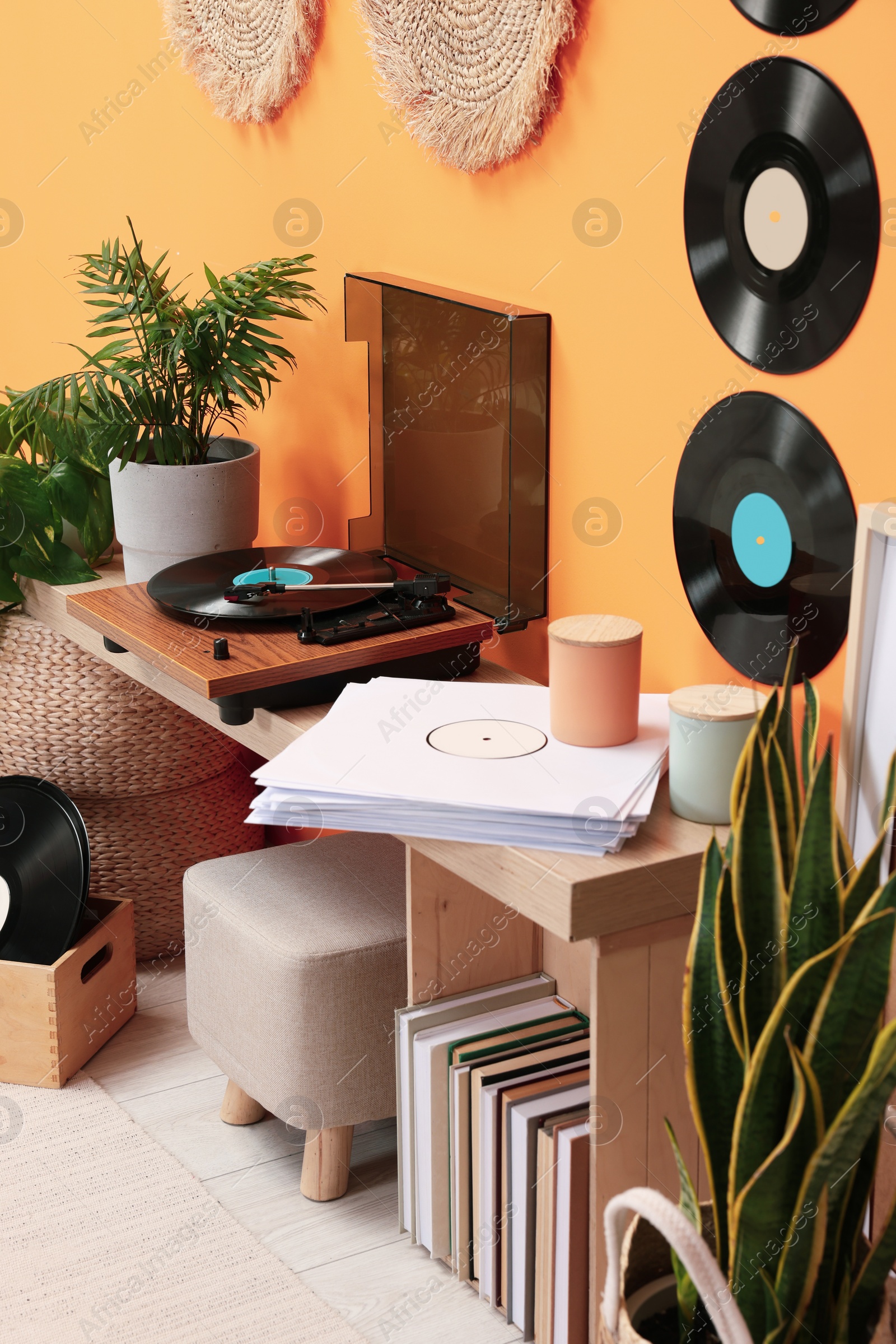 Photo of Stylish turntable with vinyl record on console table in cozy room