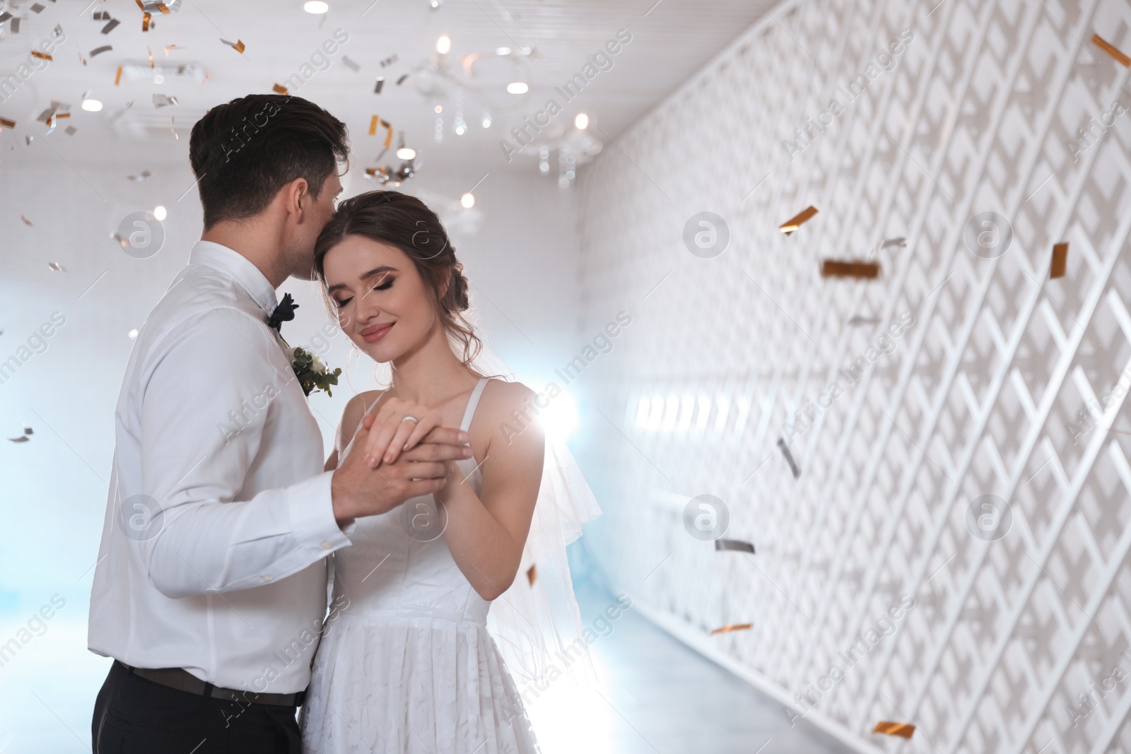 Photo of Happy newlywed couple dancing together in festive hall