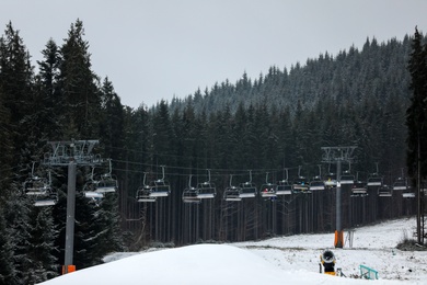 Photo of Beautiful view of ski resort with chairlift on snowy day. Winter vacation