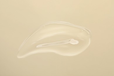 Photo of Sample of cleansing gel on beige background, top view. Cosmetic product