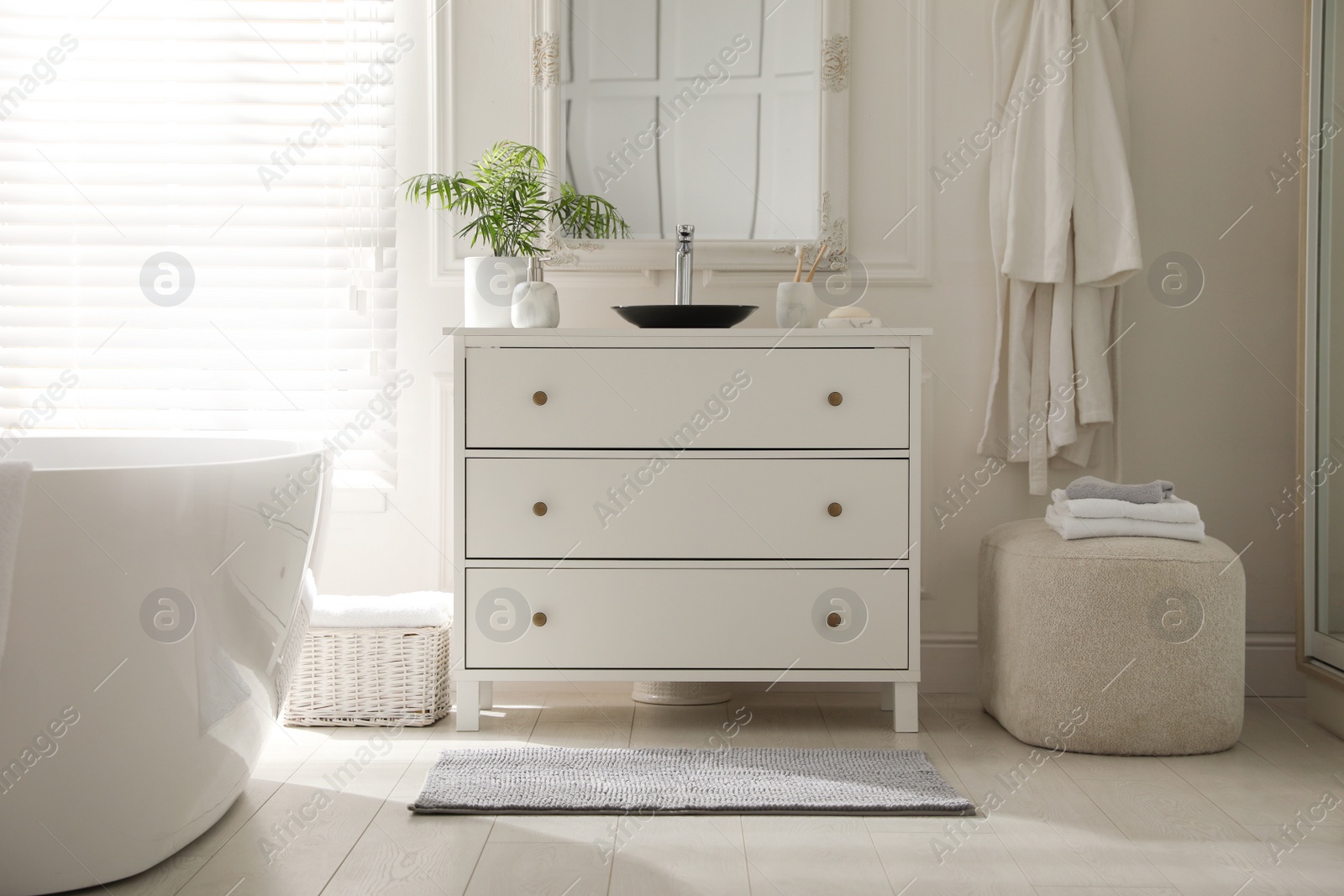 Photo of Stylish mat with pattern near chest of drawers in bathroom