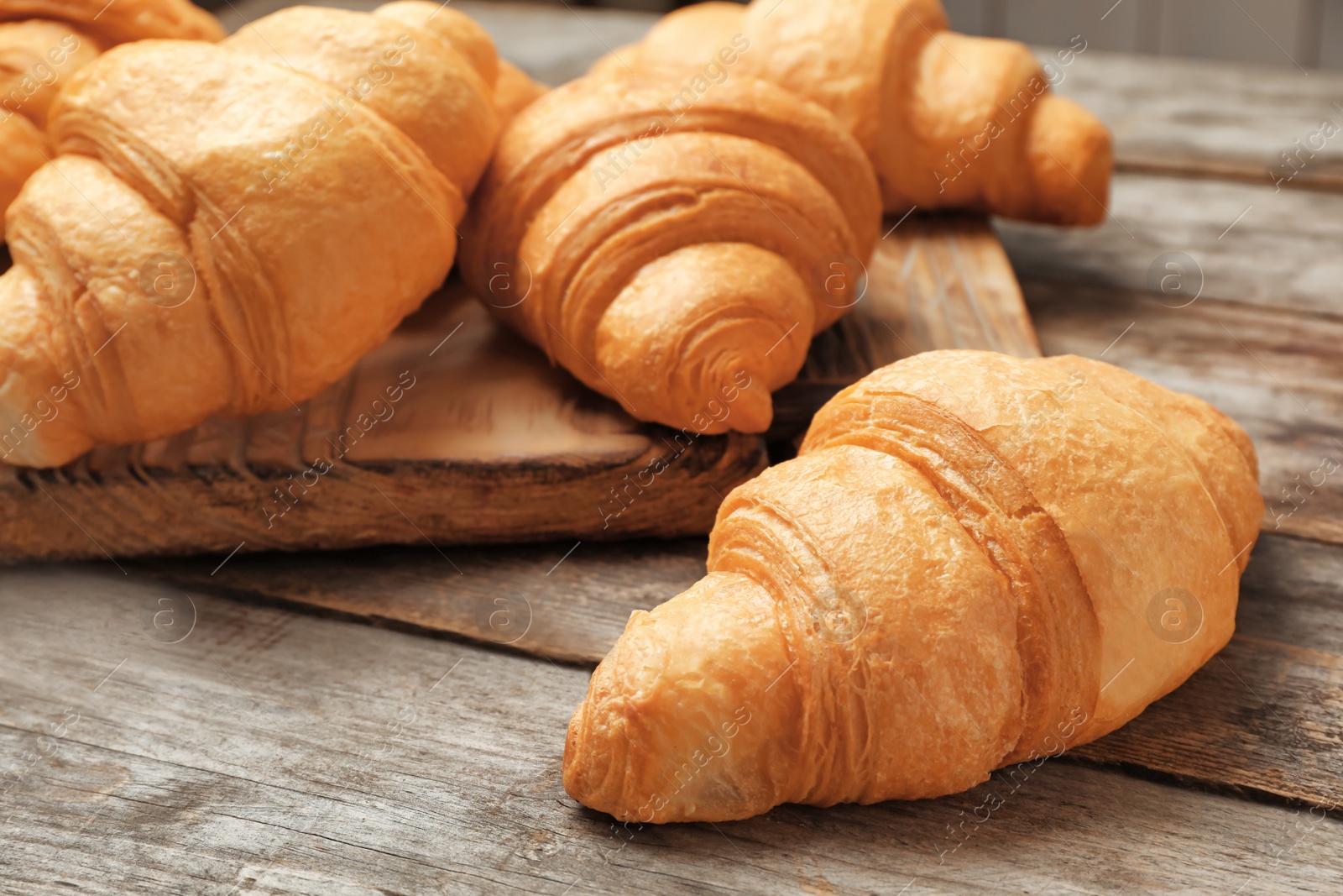 Photo of Tasty croissants on wooden table