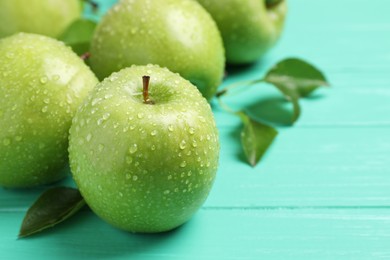 Photo of Fresh ripe green apples with water drops on turquoise wooden table, closeup