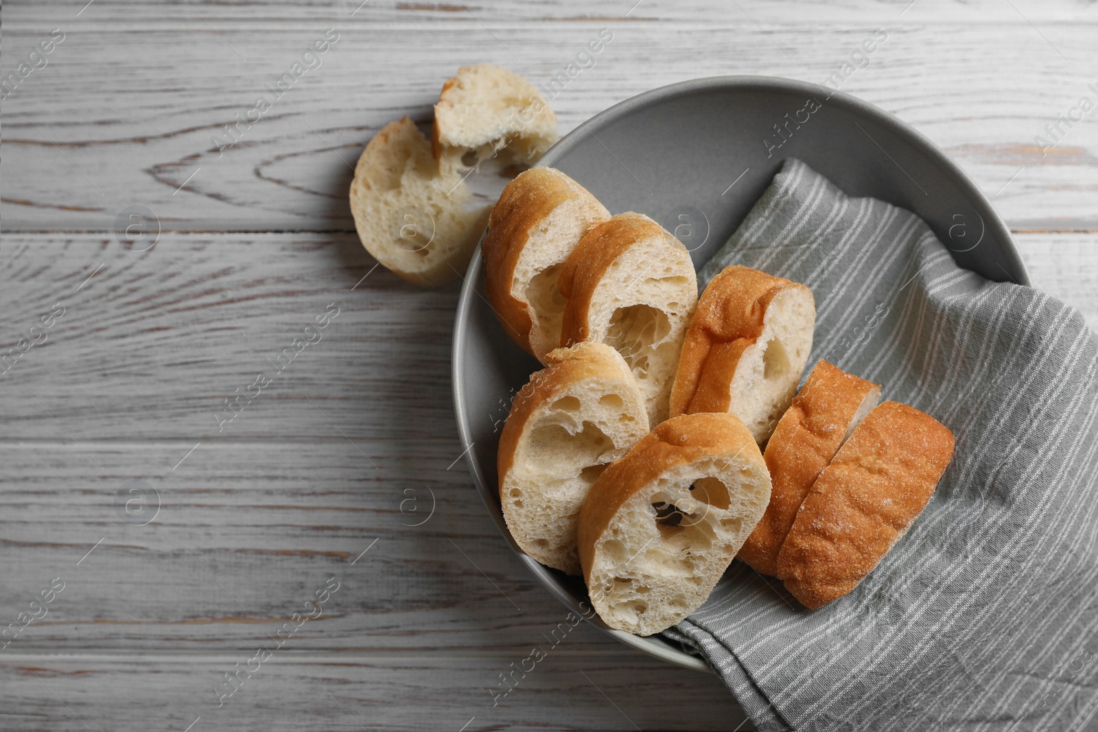 Photo of Fresh crispy ciabattas on white wooden table, flat lay. Space for text