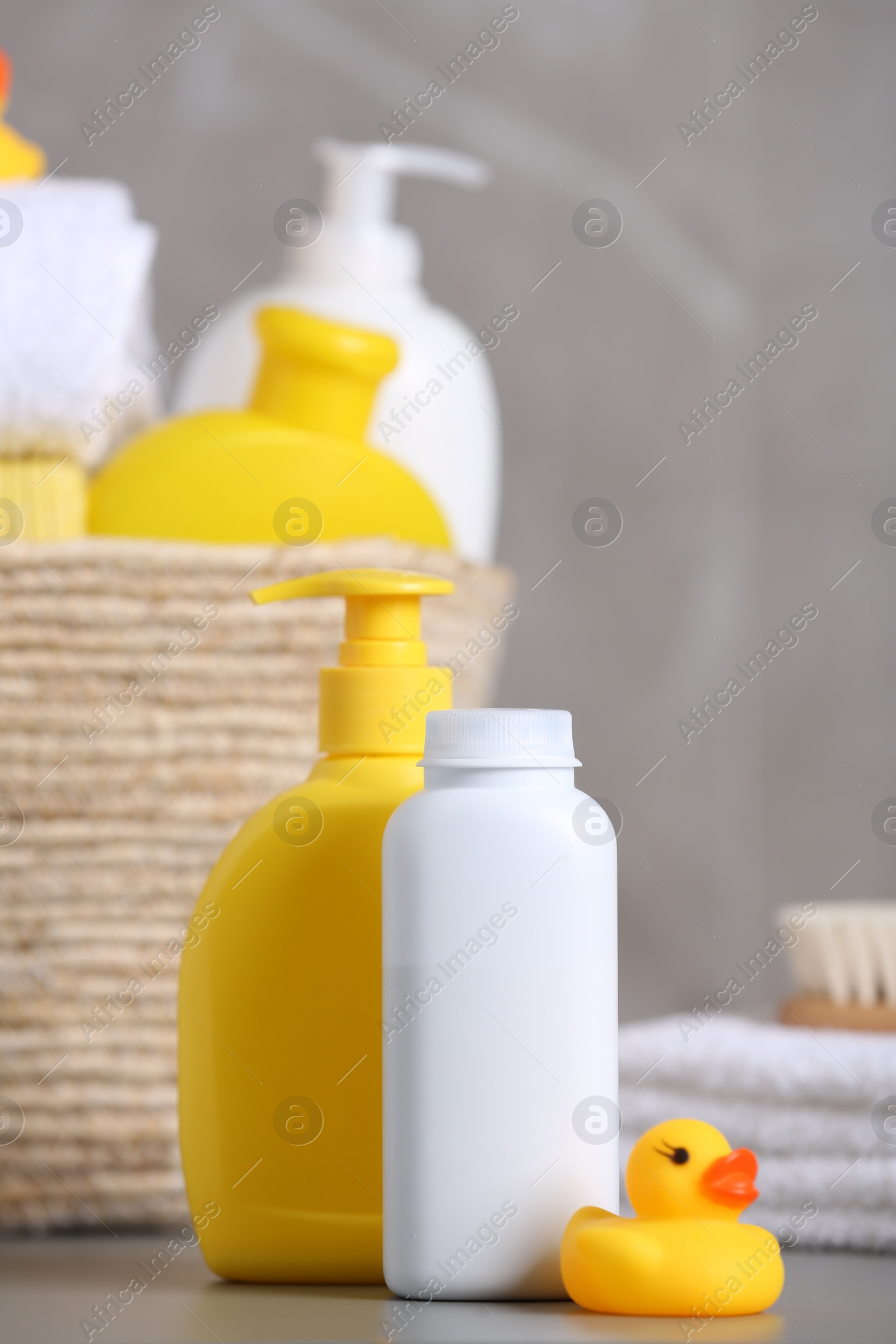 Photo of Baby cosmetic products, bath accessories and rubber duck on grey table