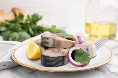 Photo of Slices of tasty salted mackerel with lemon and onion on white marble table, closeup