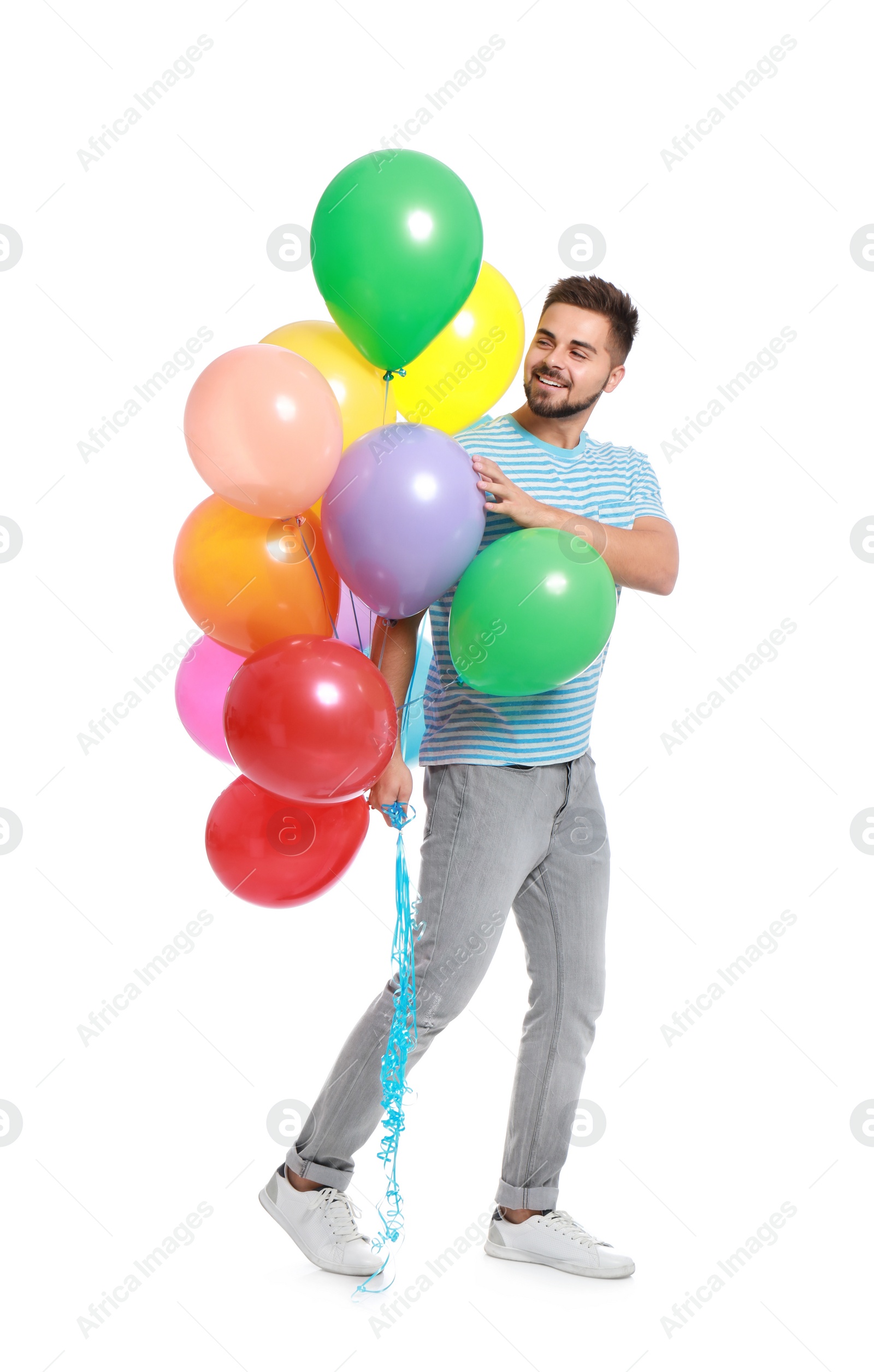 Photo of Young man holding bunch of colorful balloons on white background