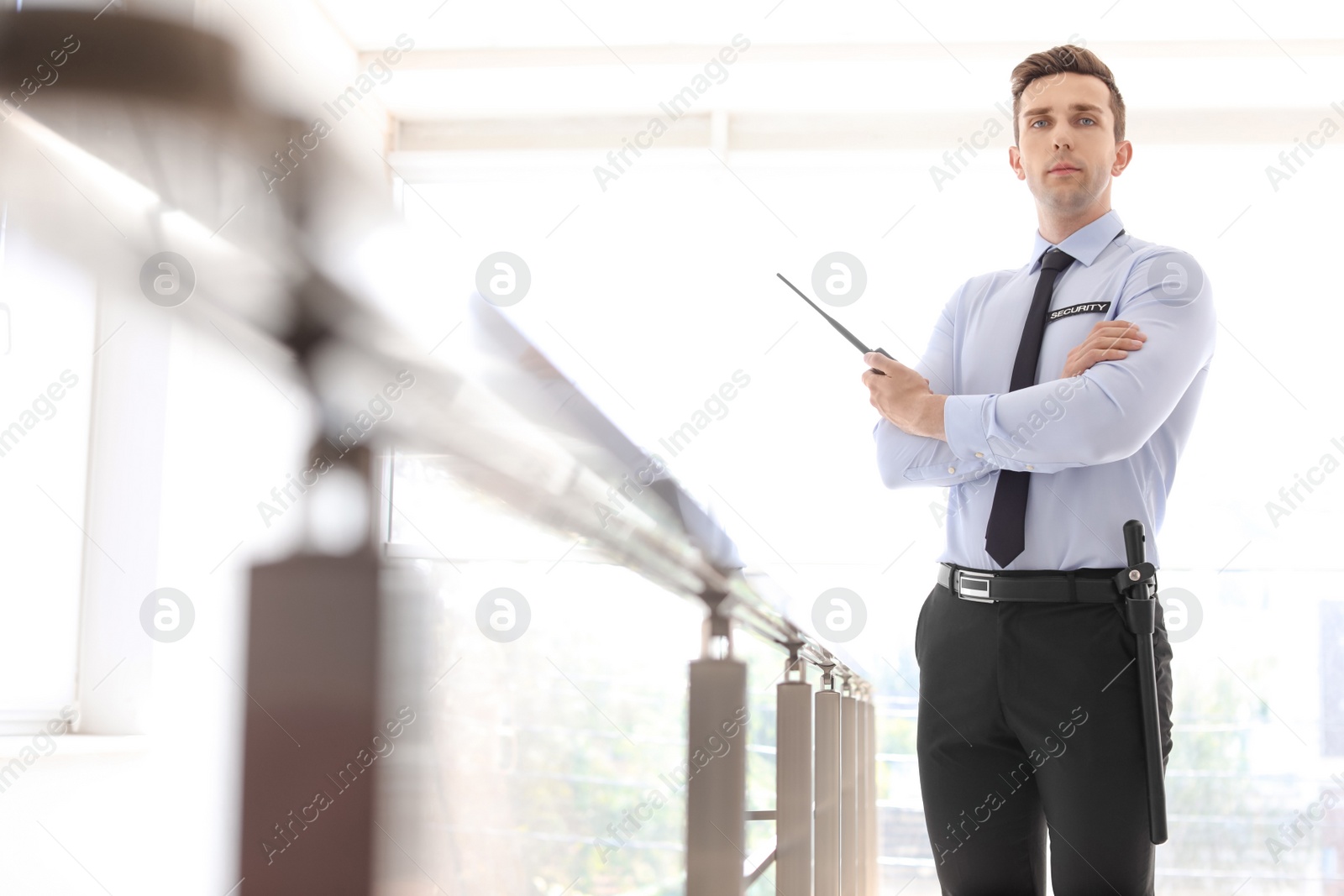 Photo of Male security guard with portable radio transmitter indoors