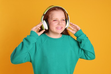 Photo of Cute indie girl in headphones on yellow background