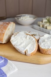 Photo of Slices of baguette with tofu cream cheese on white wooden table