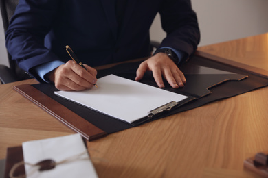 Photo of Male lawyer working at table in office, closeup