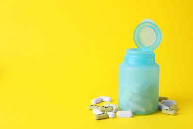 Photo of Different antidepressants with happy emoticons and medical jar on yellow background, space for text