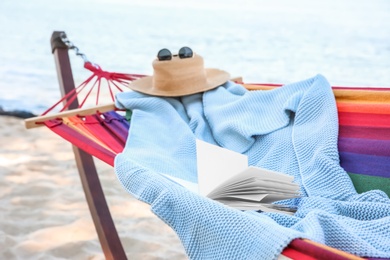 Photo of Colorful hammock with book and blanket at seaside. Time to relax