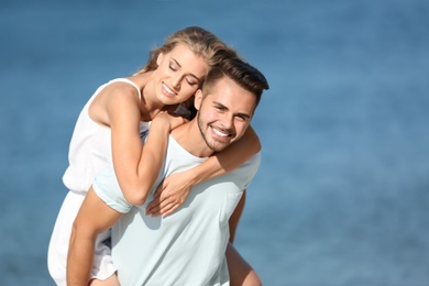 Happy young couple at beach on sunny day