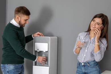 Employees having break near water cooler in office