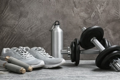 Photo of Composition with dumbbells and fitness accessories on floor